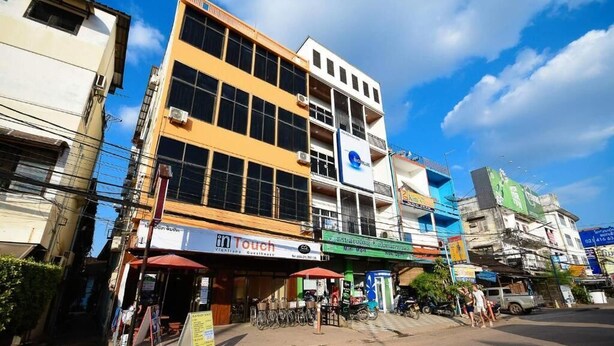 A multi-story building with various shops on the ground floor, including a visible 'inTouch' business. - Intouch vientiane (Vientiane)