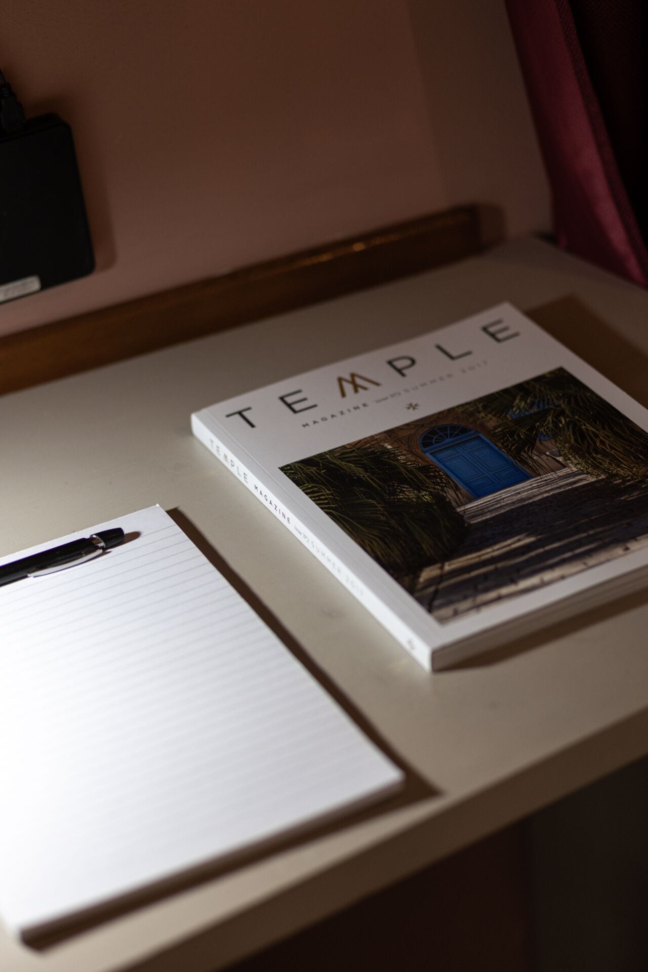 Un libro con el título 'TEMPLE MAGAZINE' sobre un escritorio.