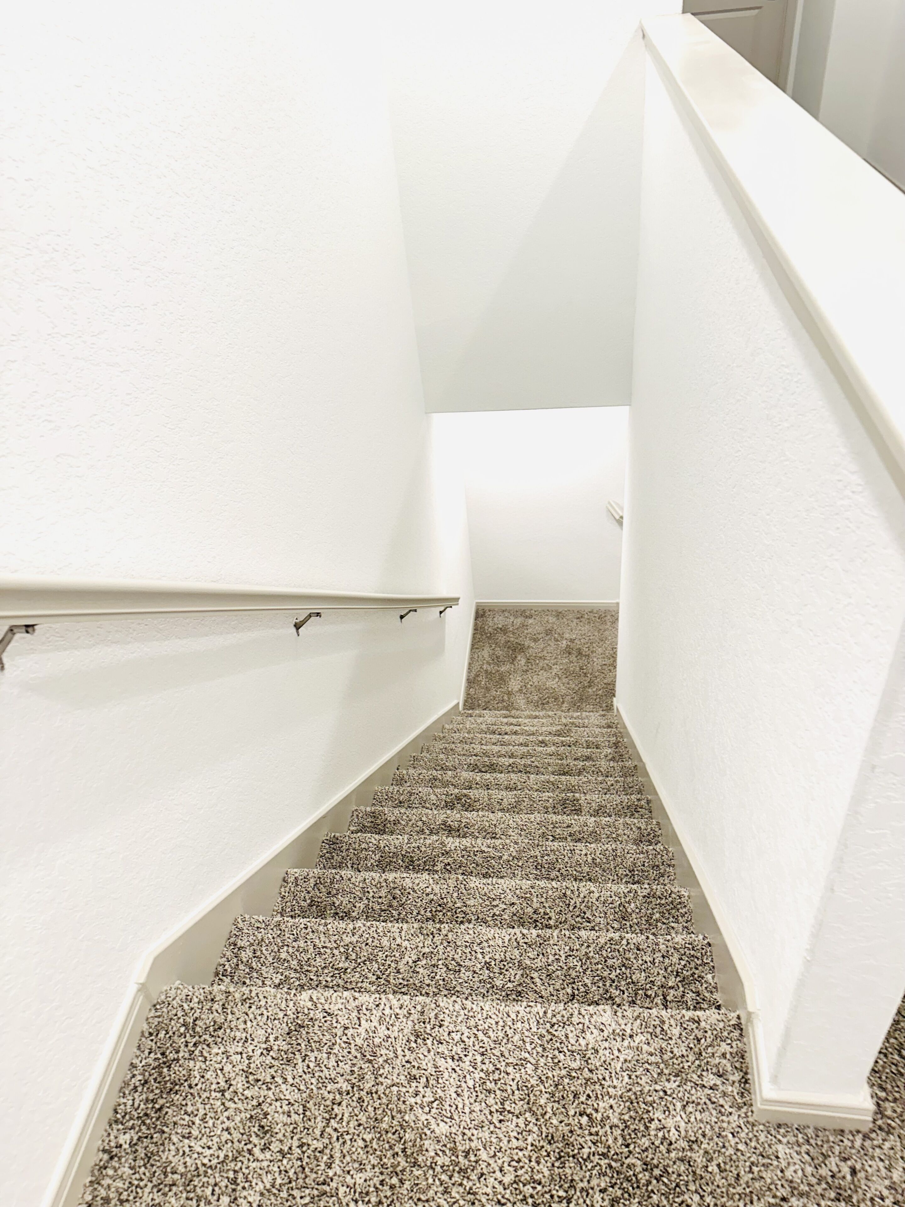 Eine Treppe mit Teppichstufen und weißen Wänden.