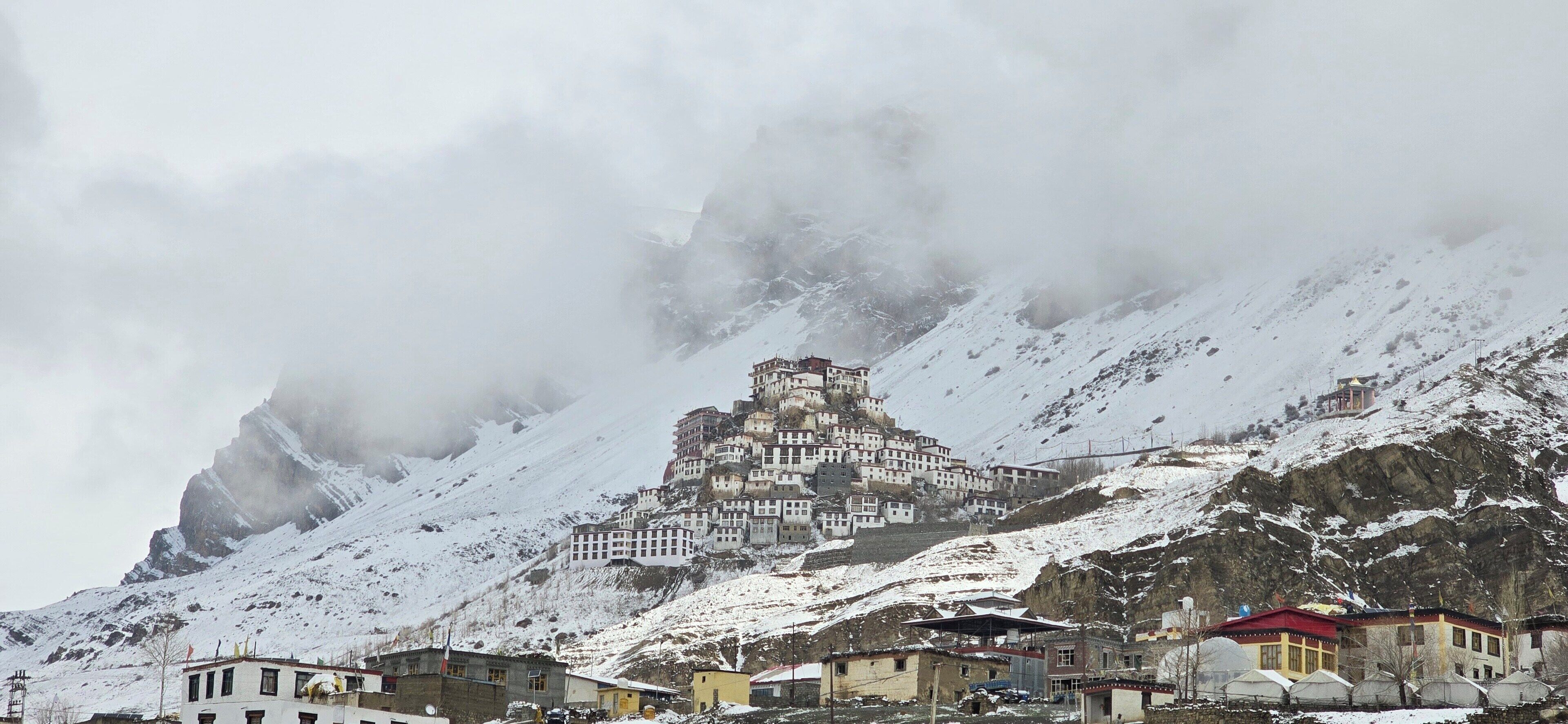 A mountainous region with a cluster of buildings, including a prominent structure on a cliff.