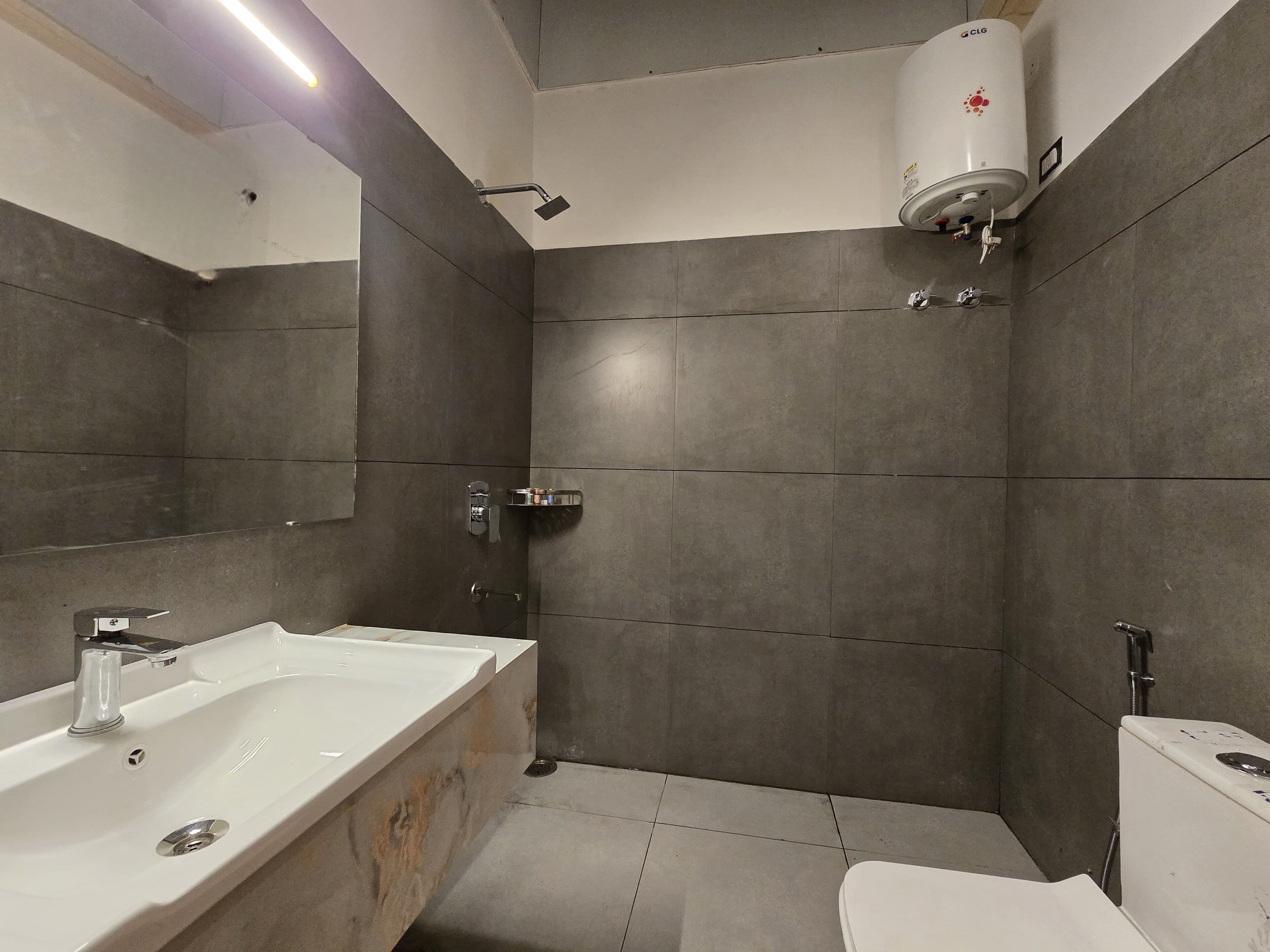 Un bany modern amb un lavabo gran, un vàter i una dutxera.