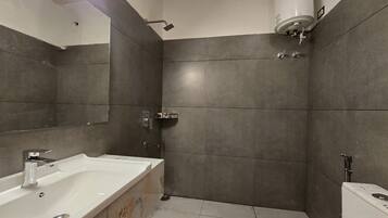 Un bany modern amb un lavabo gran, un vàter i una dutxera.