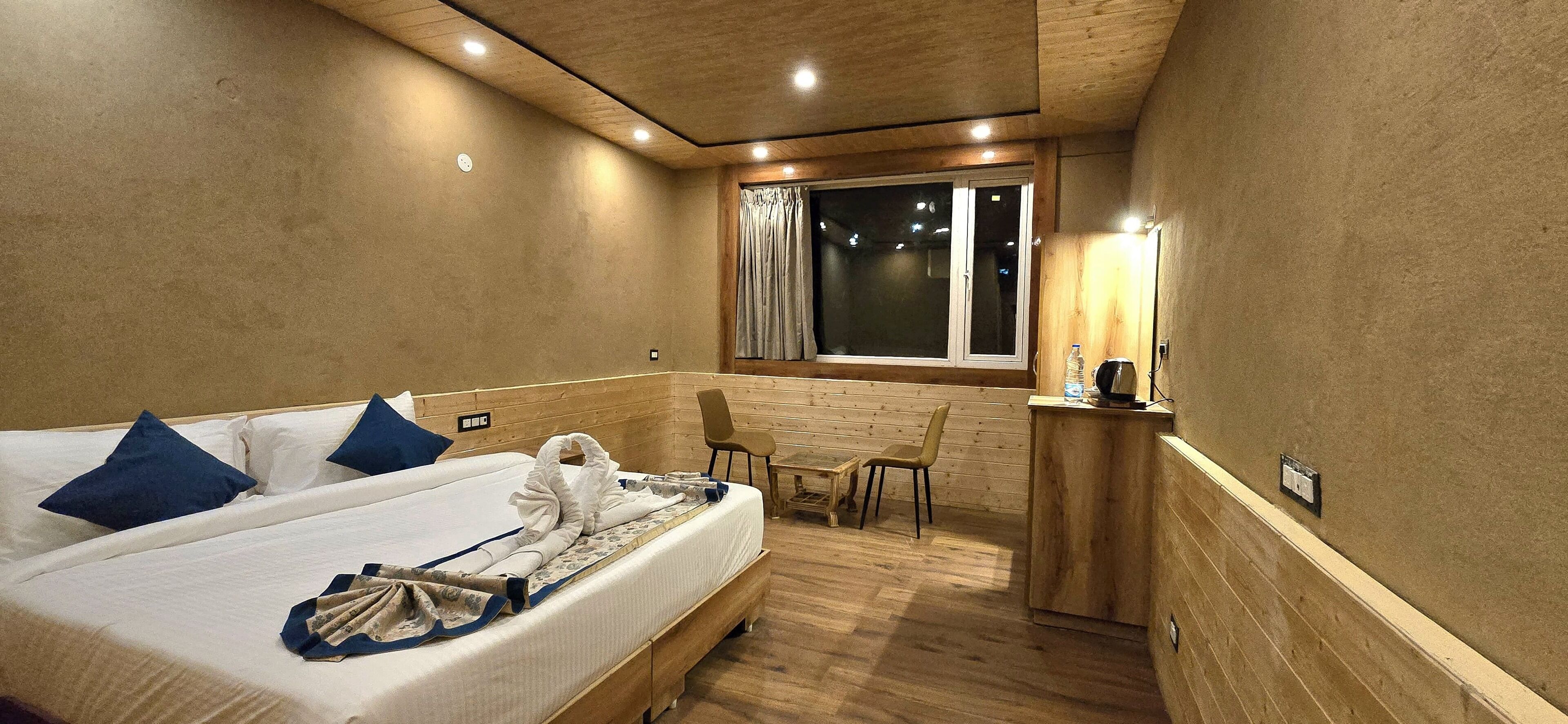 Een hotelkamer met een bed, bureau, stoel en raam.