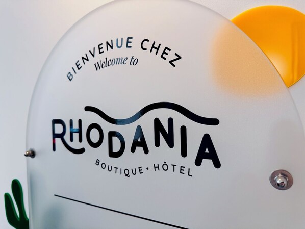 A sign with "BIENVENUE CHEZ RHODANIA" and "RHODANIA BOUTIQUE HOTEL" indicating a welcome to Rhodania Boutique Hotel. - Rhodania Boutique Hôtel (Geneva)