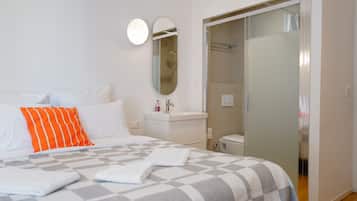 Une chambre d’hôtel avec un lit, une salle de bain avec douche et une armoire.