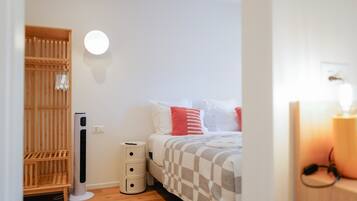 A bedroom with a bed, bedside table, and a wardrobe.