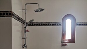 Un baño con bañera, ducha y ventana.