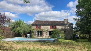 A stone house with a tiled roof, a swimming pool, and a garden. - Maison au Milieu des Vignes Proche de Saint Emilion (Mérignas)