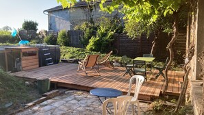 A wooden deck with outdoor furniture, a hot tub, and a stone pathway. - Maison au Milieu des Vignes Proche de Saint Emilion (Mérignas)