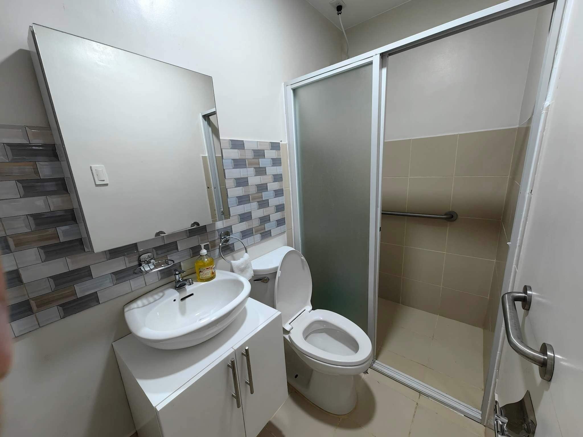 A bathroom with a sink, toilet, and shower.