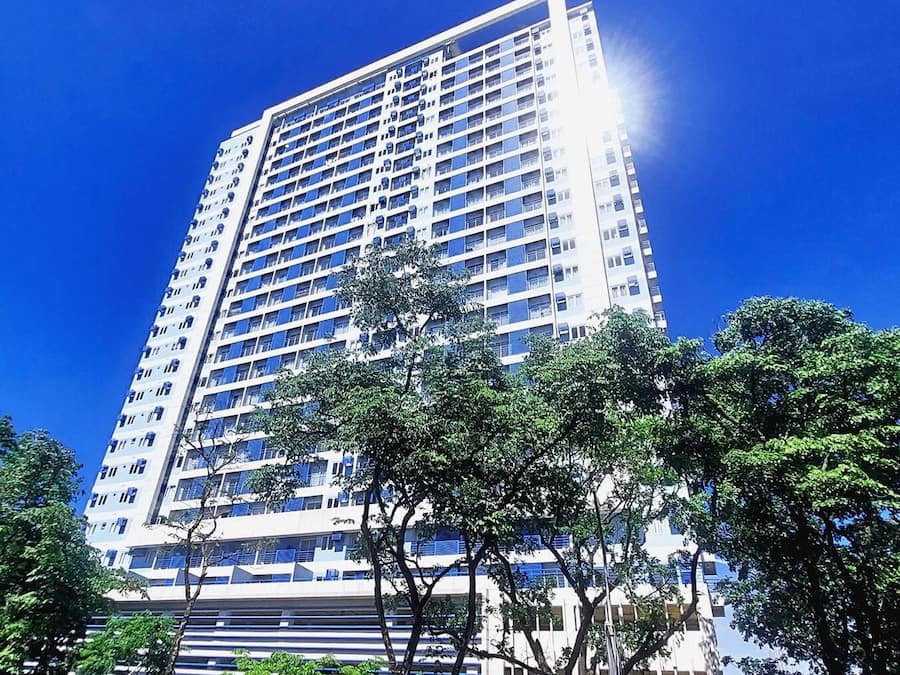 A high-rise building with multiple floors, large windows, and a clear sky.