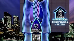 A hotel entrance with a modern design, featuring a prominent logo and bilingual signage. - Home me Hotel (Makati)