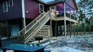Une maison à deux étages avec un escalier en bois menant à un balcon.