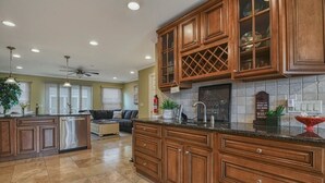 A spacious kitchen with wooden cabinets, a central island, and a dining area with a sofa.