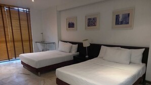 A hotel room with two beds, a desk, and a chair. There are three framed pictures on the wall. - AW HOTEL LUXOR VERSALLES (Cali)