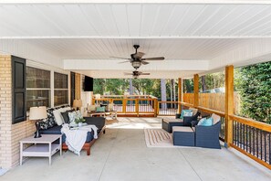 A covered porch with a ceiling fan, outdoor seating, and a view of the backyard. - 3 bedroom 2 bathroom home with fenced yard that allows pets. The sleeping arrangements are 3 queen beds. (Augusta)