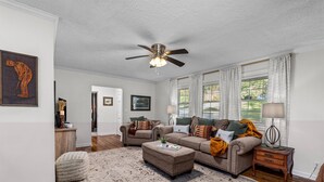 A living room with a ceiling fan, two sofas, a coffee table, and a rug.