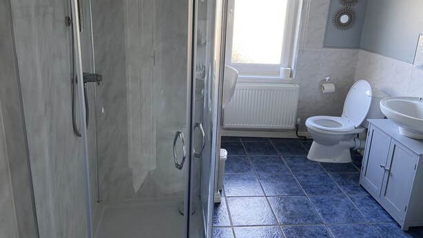 Un baño con ducha, inodoro y lavamanos.