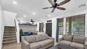 A modern living room with a sofa, coffee table, and a staircase. - Cuban inspired Mid Term Rental in the heart of Gilbert  (Gilbert)