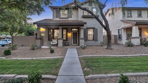 A two-story house with a front porch, a driveway, and a small front yard. - Cuban inspired Mid Term Rental in the heart of Gilbert  (Gilbert)