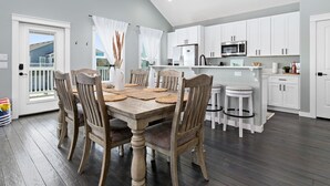 Una cocina moderna con armarios blancos, un refrigerador de acero inoxidable y un microondas.