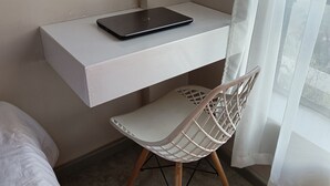 A small, modern room with a white desk, a laptop, a white chair, and a bed. - Quiet Urban Stay with Views, 0742 for 616 then 120 (Nairobi)