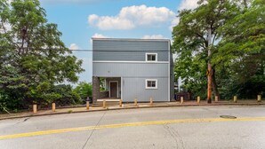 A two-story building with a grey exterior and a small entrance. - Unmatched City View! King Bed, 2BR Apt. Free Parking! (Pittsburgh)