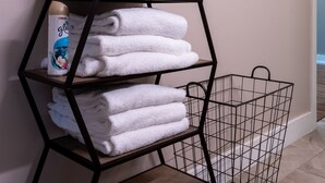 A bathroom with a metal towel rack, a metal shelf with folded towels, and a basket. - Unmatched City View! King Bed, 2BR Apt. Free Parking! (Pittsburgh)