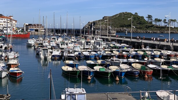 A marina with numerous boats docked, a pier, and a hilly landscape in the background. - Céntrico Apartamento en Lekeitio - Urrondo (Lekeitio)