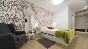 A modern bedroom with a bed, bedside tables, a chair, and a wardrobe. - VIZCAINOS GARDEN (Segovia)