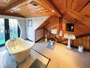 A bathroom with a freestanding bathtub, a toilet, and a sink.