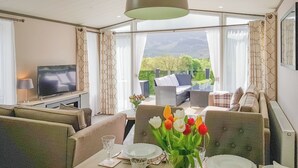 Une chambre d’hôtel dotée d’un coin repas, d’une télévision et d’un balcon aménagé avec du mobilier d’extérieur.