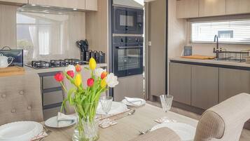 A modern kitchen with a dining area, equipped with a stove, oven, and microwave.