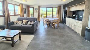 A spacious living area with a sofa, a dining table, and a kitchen area with modern appliances.