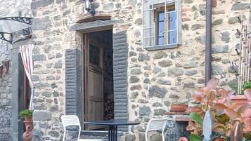 Relax in a charming outdoor space with a small table and two chairs, perfect for casual dining or unwinding.