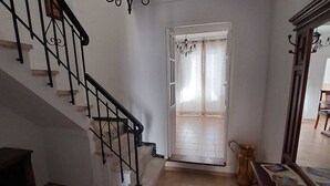 A staircase with a chandelier, a wooden cabinet, and a door leading to another room. - Casa Jaro en el Centro del Pueblo (Sierra de Yeguas)