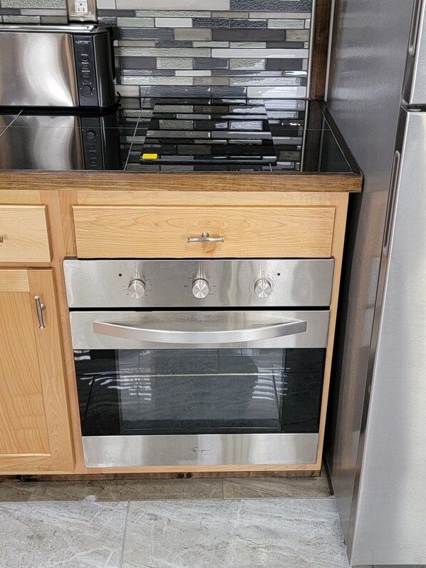 Una cocina con horno empotrado, microondas y estufa.