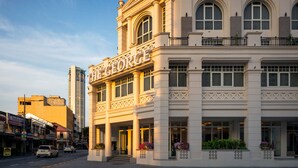 A historic building with a prominent name sign, large windows, and a balcony with railings. - The George Penang By The Crest Collection (George Town)