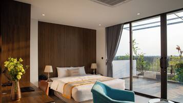 Una habitación de hotel moderna con una cama grande, un escritorio con una computadora portátil, un florero y un balcón con vistas.