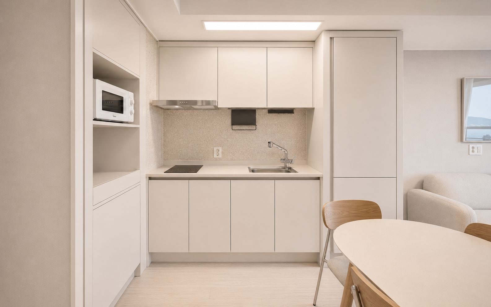 A compact kitchen with a microwave, stove, and sink.