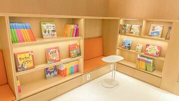 Una biblioteca infantil con estanterías llenas de libros y una pequeña mesa blanca.