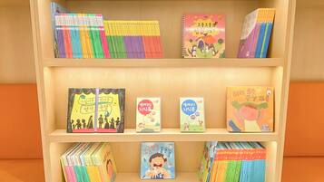 A bookshelf with various books and colorful notebooks.