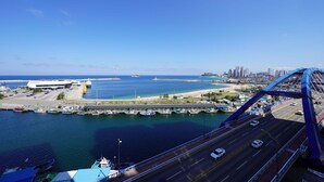 A coastal cityscape with a bridge, marina, and high-rise buildings. - UH FLAT THE SOKCHO (Sokcho)