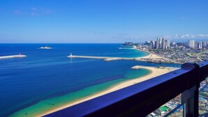 A coastal cityscape with a prominent beach, clear blue waters, and high-rise buildings. - UH FLAT THE SOKCHO (Sokcho)