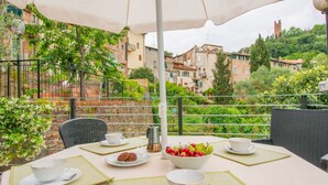 A table set for two with a view of a hillside town.