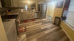 A modern kitchen with a central island, stainless steel appliances, and a tiled backsplash. - Charming 3 Bed 2 Bath Home in NE San Antonio (Converse)