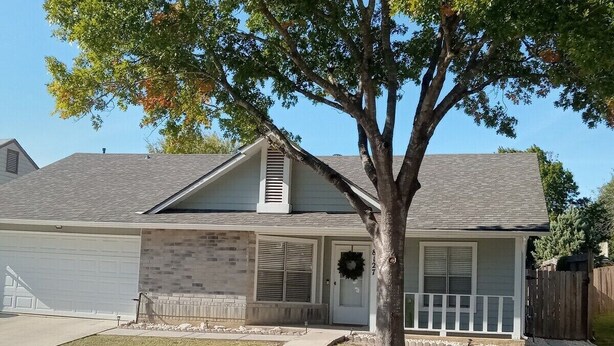 A single-story house with a front porch, a garage, and a tree in front. - Charming 3 Bed 2 Bath Home in NE San Antonio (Converse)