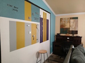A living room with a wall clock, a desk, a chair, and a sofa. - Charming 3 Bed 2 Bath Home in NE San Antonio (Converse)