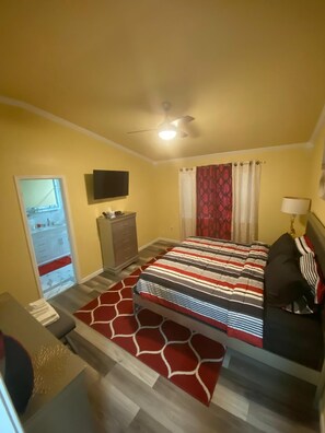 A bedroom with a bed, a dresser, a TV, a ceiling fan, and a window with curtains. - Charming 3 Bed 2 Bath Home in NE San Antonio (Converse)
