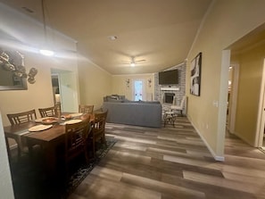 Un salón amplio con mesa de comedor, sofá y chimenea.